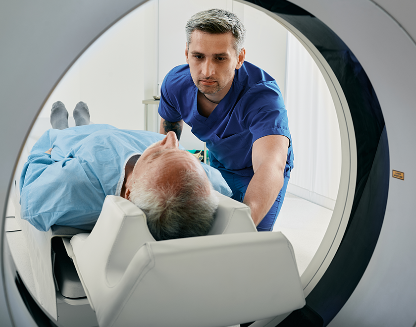 Practitioner assisting patient into a MRI
