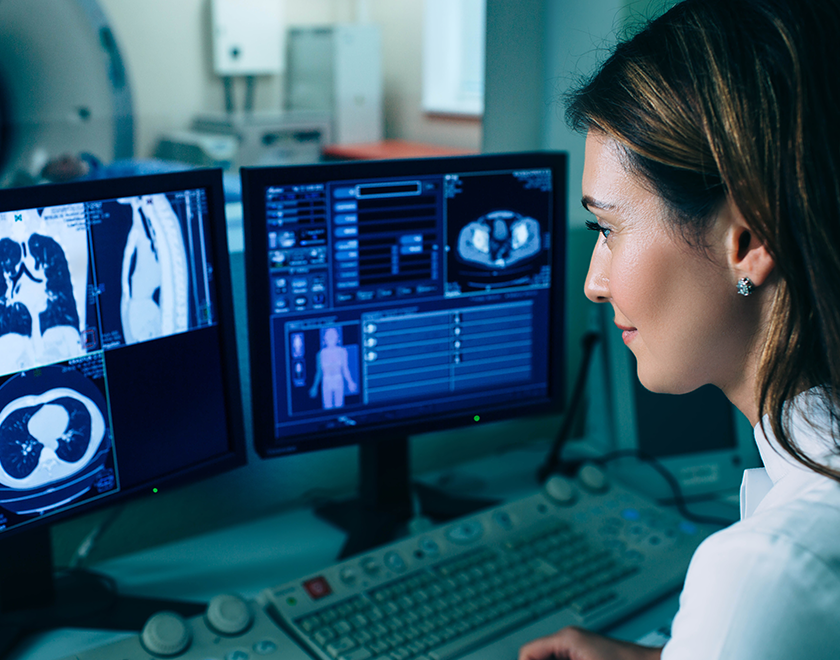 Practitioner looking at x-rays on monitors